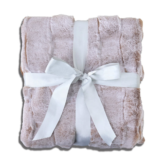A folded soft pink plush blanket with a velvety texture, elegantly tied with a wide white satin ribbon bow at the center. The clean white background accentuates the blanket's gentle hue and the ribbon's crisp contrast, creating a warm, inviting aesthetic suitable for gift presentation or cozy home decor.