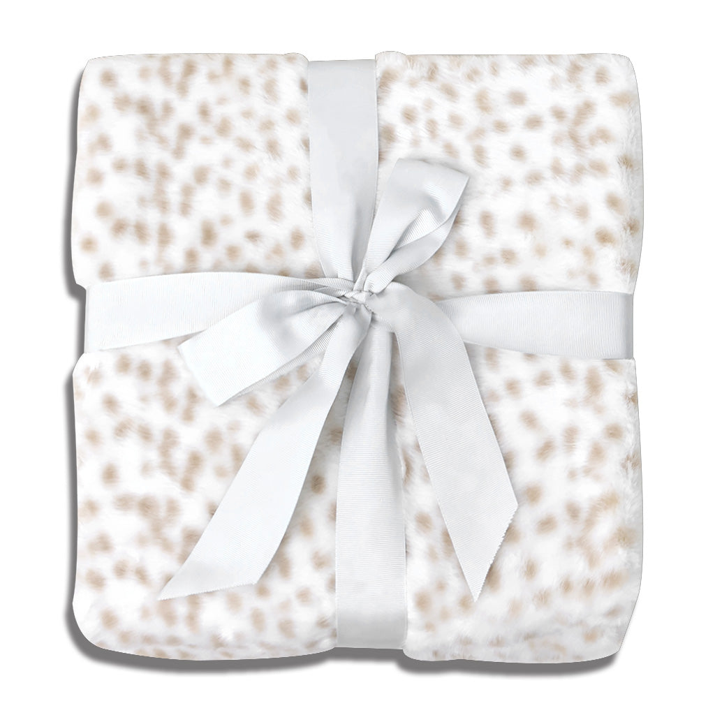 Square faux-leopard print throw blanket in ivory and caramel tones, featuring irregularly shaped soft-focus spots. Ultra-plush polyester velvet fabric with directional pile creates texture depth. Central satin ribbon accent adds tactile contrast. Displayed against clean white background, emphasizing its role as a versatile home decor piece.