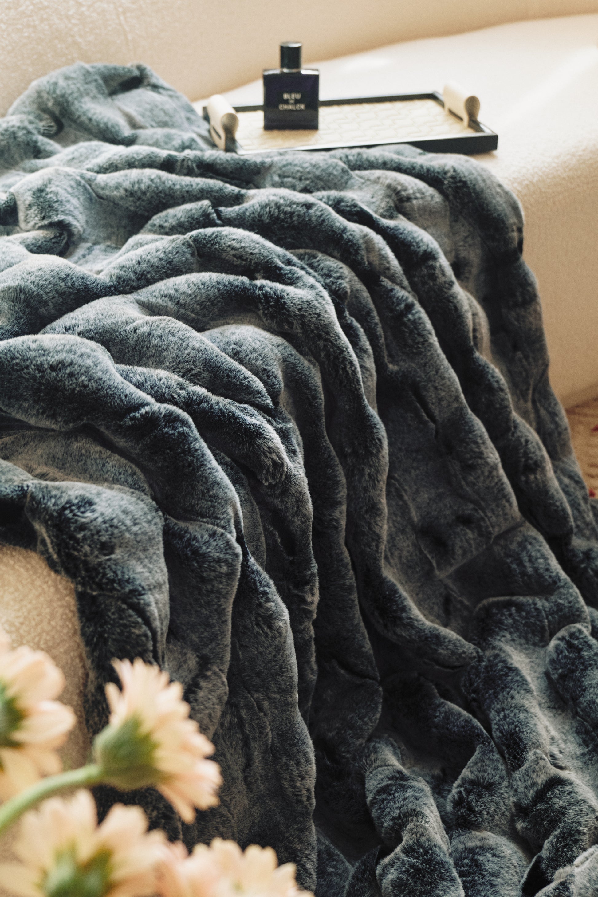A sleek black-to-charcoal throw with a sumptuous velvet finish, geometric quilting, and a single silver thread accent, exuding modern luxury.