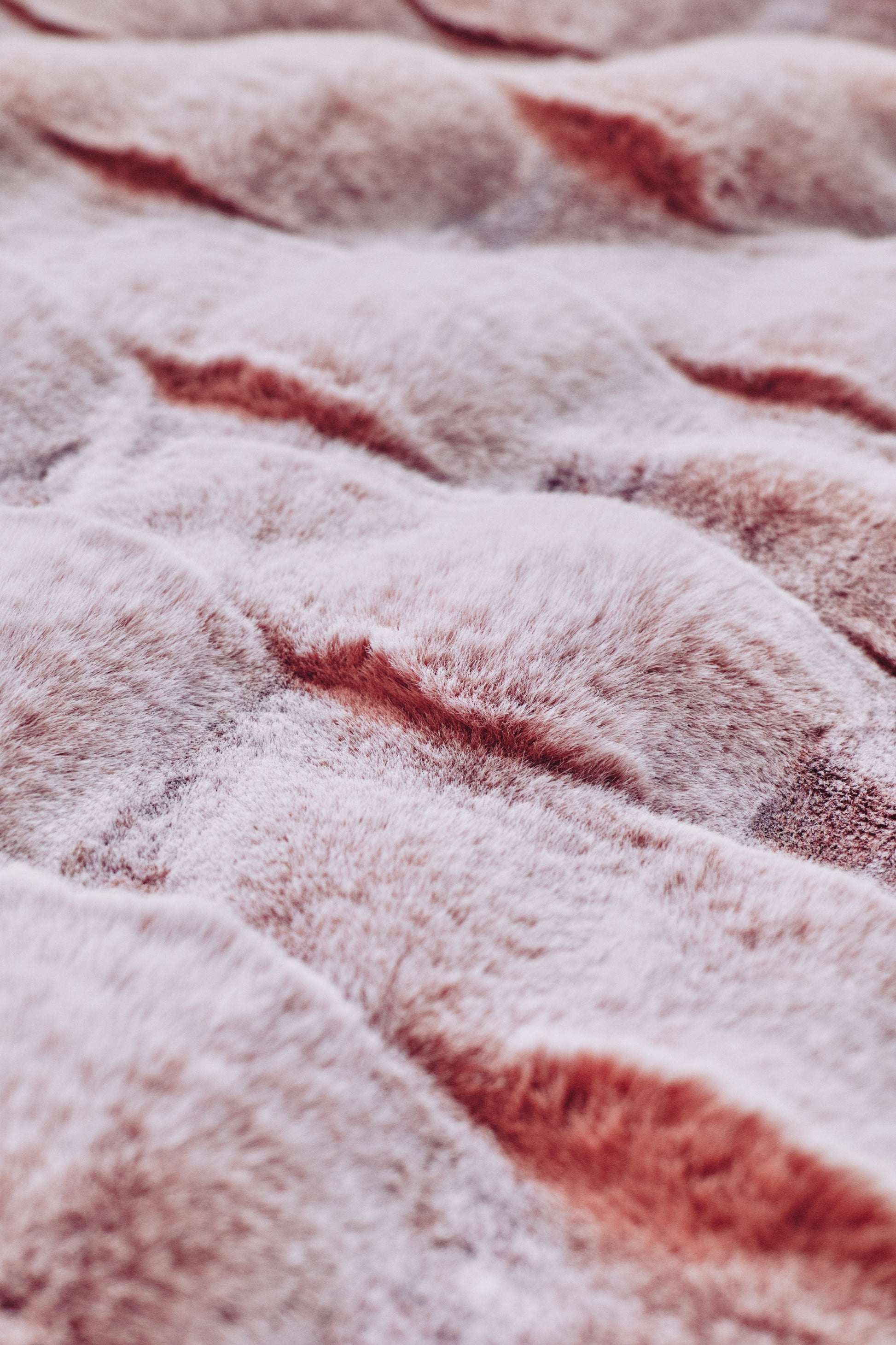 A whimsical pink-to-lavender throw with a spiral quilted pattern, velvety-soft surface, and subtle metallic thread accents, perfect for adding playful elegance.