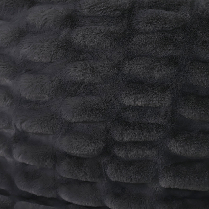 A close-up of a dark plush fabric with raised rounded segments arranged in a grid pattern.