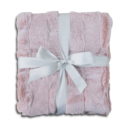 A folded soft pink plush blanket with delicate fluffy texture, elegantly wrapped with a wide white satin ribbon and tied into a bow at the center. The clean white background emphasizes the item's warmth and coziness, creating a gift-ready presentation with a harmonious pink-and-white color scheme.