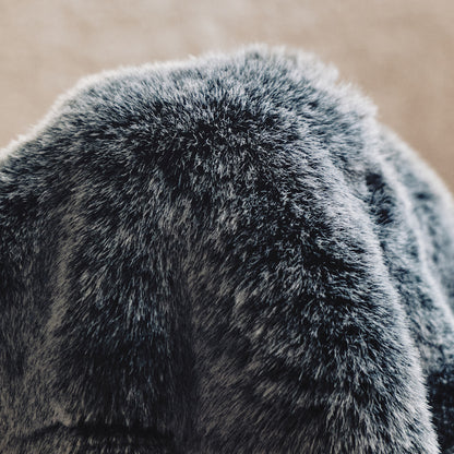 A muted gray-to-black design with a chunky knit texture, frayed edges, and a casual draped style, offering relaxed sophistication.