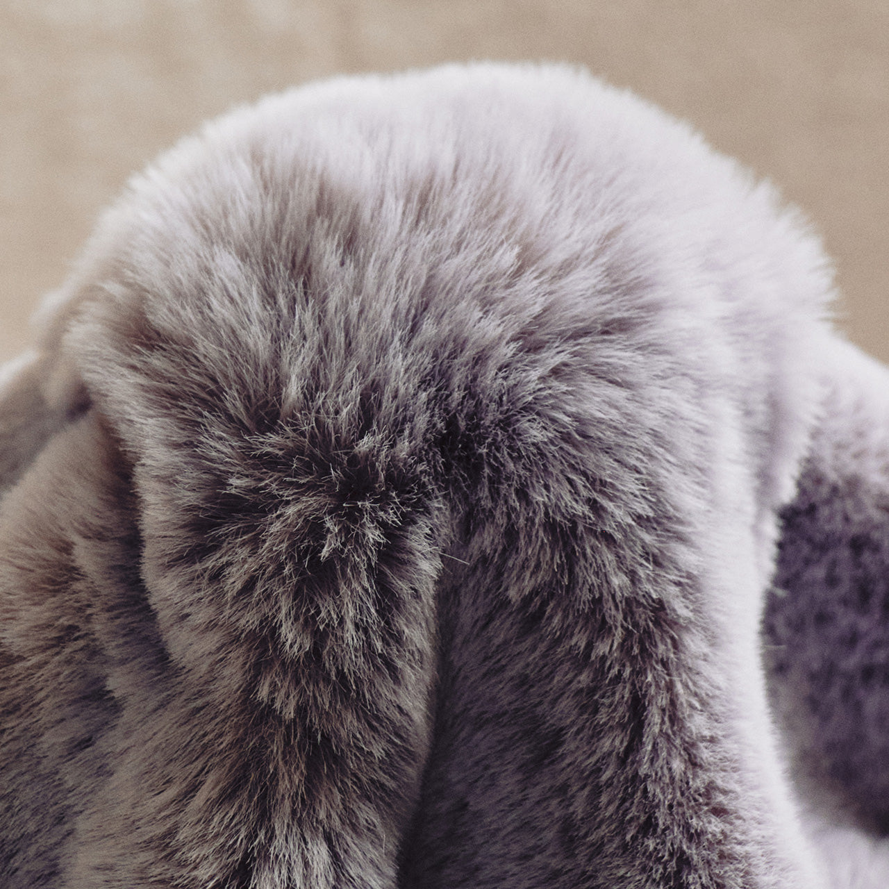 A plush gray-to-lavender gradient blanket with a fur-like texture, embracing a minimalist, natural aesthetic through its seamless color blend and unadorned design.